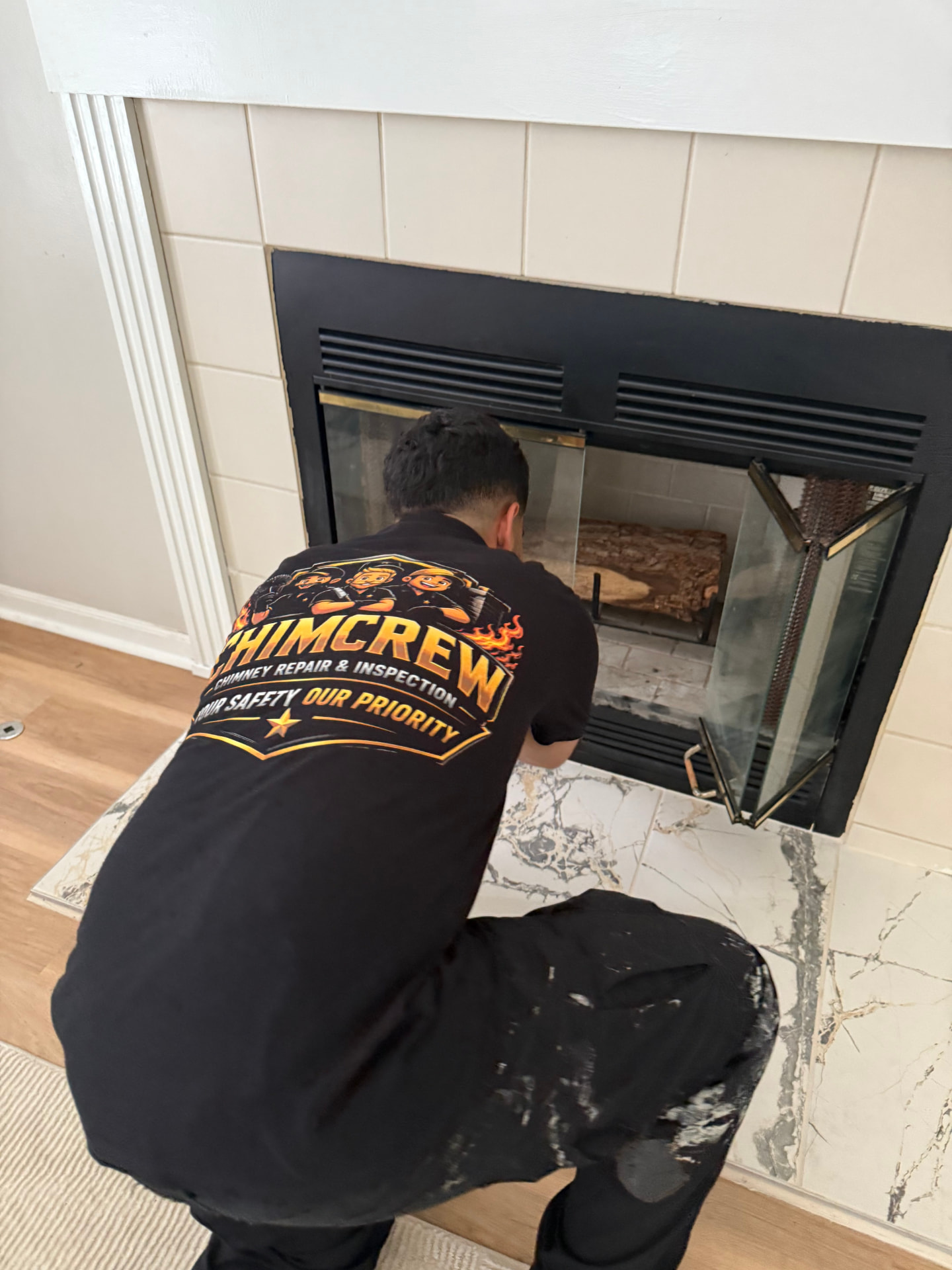 ChimCrew technician cleaning a fireplace inside a home
